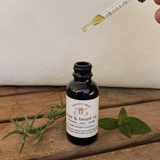 a jar and dropper of all natural hair and beard oil created by honeybee hippie to strength and nourish hair with natural ingredients to stimulate growth