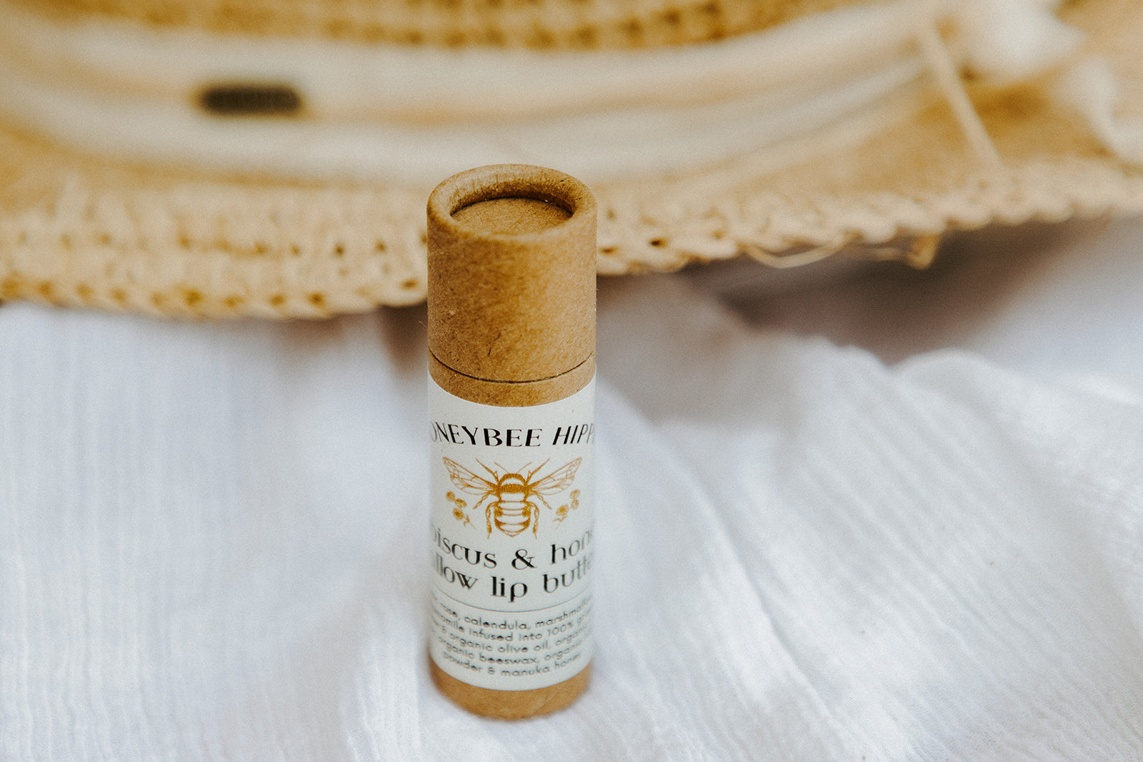 a closed tube of lip butter made by honeybee hippie with tallow and natural ingredients for soothing sunburn and healing skin on the lips