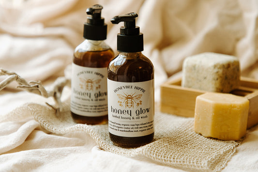 two bottles of all natural organic oil face wash created with honey and herbs for cleansing skin made by honeybee hippie to clear and soothe skin